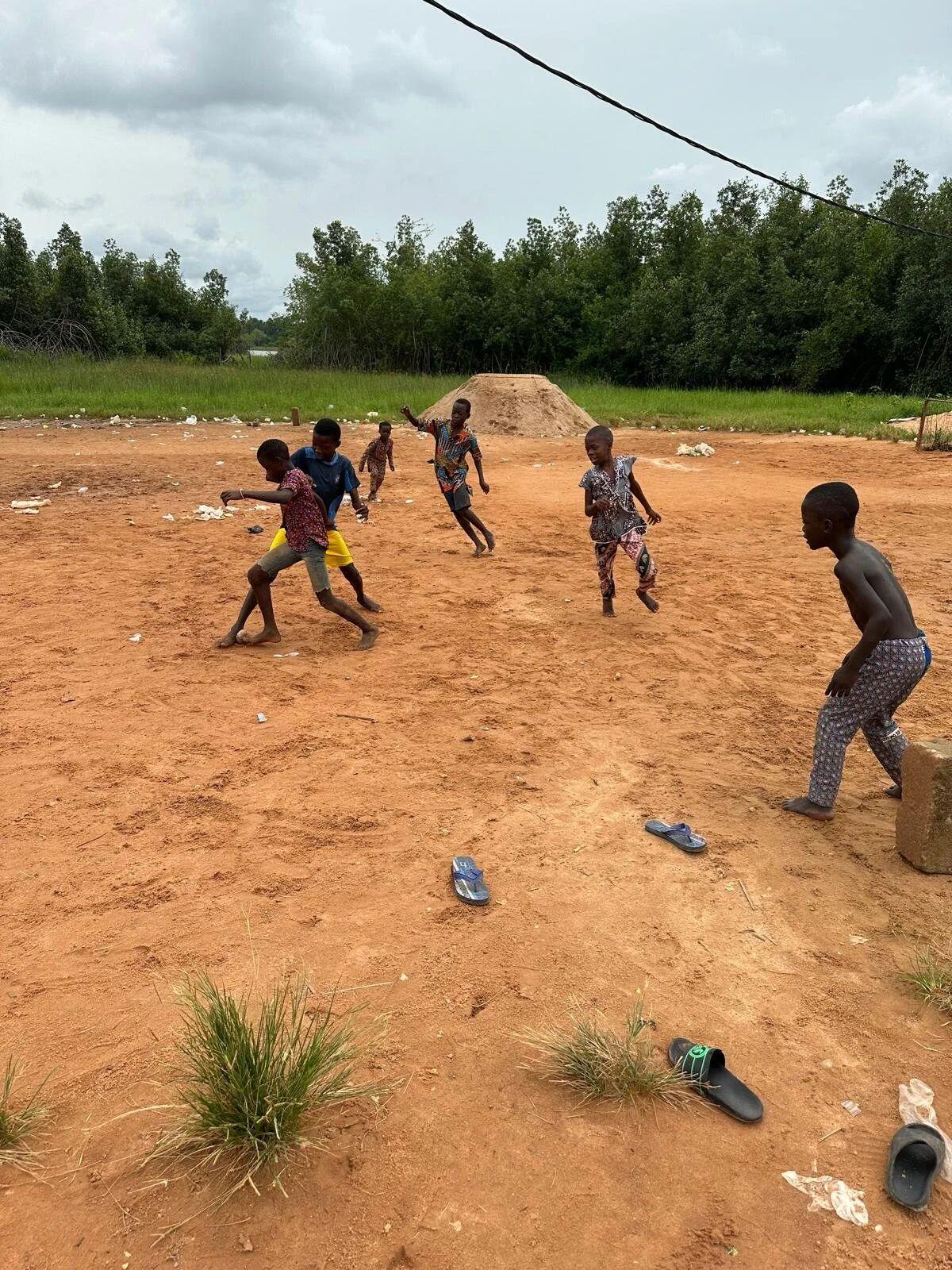 Children playing football in a lagoon-side village